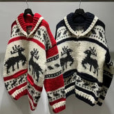 Two knitted sweaters with reindeer pattern on hangers